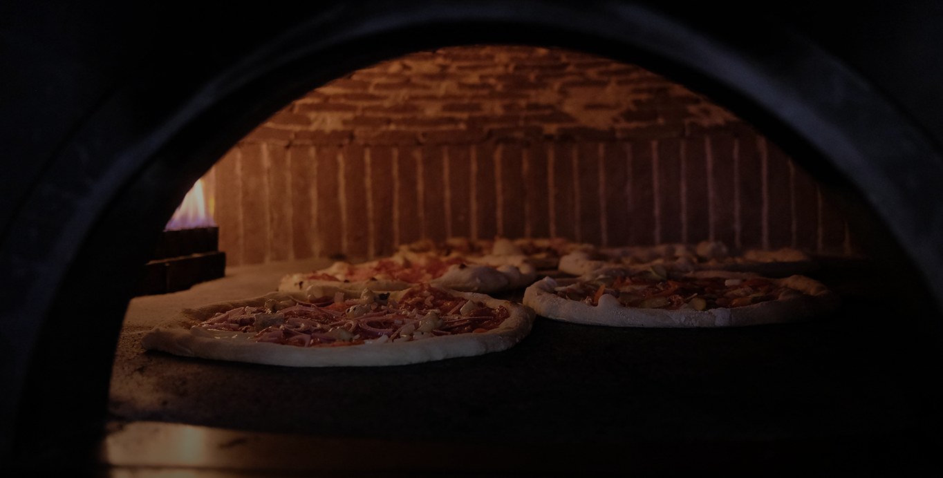 Pizza rumenindu-se în flacăra deschisă a cuptorului Visciano pe lemne